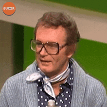 a man wearing glasses and a polka dot shirt with a buzzr logo in the corner
