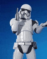 a stormtrooper from star wars is holding a gun against a blue sky .