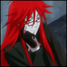 a man with long red hair is wearing glasses and a black suit .