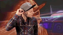 a man wearing a plaid shirt and a hat with a patch that says ' abercrombie & fitch ' on it
