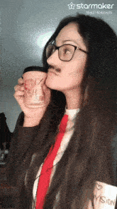 a woman wearing glasses and a mustache is drinking from a cup that says i love vision