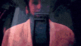 a blurry picture of a person 's face with a pink jacket on
