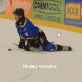a hockey player is kneeling down on the ice in front of an omnicol banner