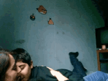 a man and woman are kissing in front of angry birds hanging on the wall