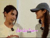 two women are standing next to each other with one wearing a hat