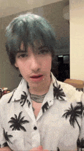a young man with blue hair is wearing a palm tree shirt