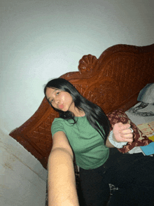 a woman laying on a bed with a louis vuitton pillow on the bed