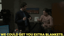 a man is putting a blanket on a woman 's lap and the words we could get you extra blankets are above them