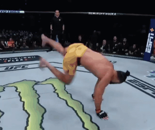 a man is doing a handstand in a ufc ring with a monster energy logo on the floor
