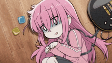 a girl with pink hair is laying on the floor with a guitar in the background