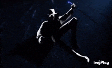 a silhouette of a man in a top hat is holding a sword in the dark .