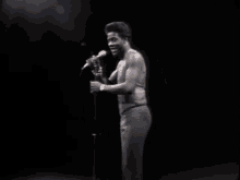 a man singing into a microphone on a stage in a dark room