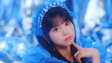 a girl wearing a blue headband with pearls and rhinestones