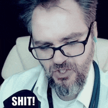 a man with glasses and a beard has the word shit written on his shirt
