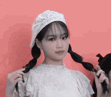 a girl with pigtails wearing a white lace top and a white hat