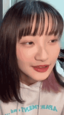 a close up of a girl 's face wearing a white hoodie that says tmt