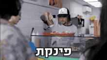 a man wearing a white hat with the letter l on it is preparing food
