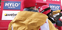 a person wearing a red helmet with hylo for dry eyes on it