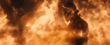a man in a helmet is surrounded by flames in a dark room