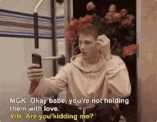 a man is taking a picture of himself with a cell phone while talking to someone
