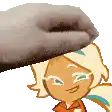 a hand is putting a cookie on top of a cartoon character .