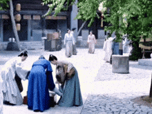a group of people in blue and white robes are standing around