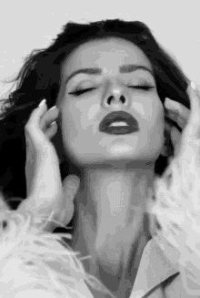 a black and white photo of a woman covering her ears
