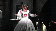 a woman in a white dress is dancing in front of a sign that says black