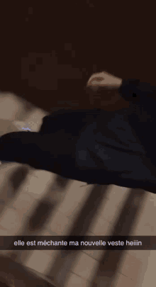 a person laying on a staircase with a caption that says elle est mecante ma nouvelle veste heiiiin