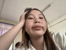 a girl with long hair is making a funny face with her hand on her head