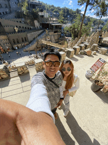 a man and a woman are taking a selfie in front of a sign that says ' a castle ' on it