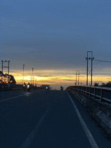 a couple of motorcycles are driving down a highway at sunset