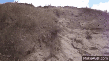 a gif of a sandy hill with the words makeagif.com below it