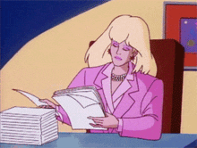 a woman in a pink suit is sitting at a desk with a stack of papers in front of her