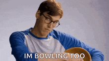 a man wearing glasses and a blue shirt is holding a bowl and says im bowling too
