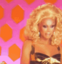 a woman with blonde hair and a black dress is wearing a wig .