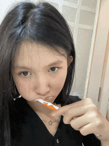 a girl brushing her teeth with a toothbrush