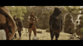 a group of monkeys and a bear standing on a dirt hill