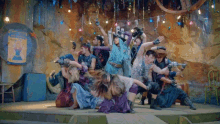 a group of people are dancing on a stage in front of a sign that says " welcome to the show "