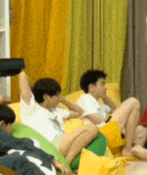 a group of people are sitting on bean bags on a couch .