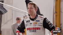 a man wearing a jacket with the word discount tire on it