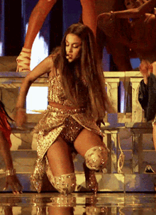 a woman in a sequined dress is kneeling on the floor