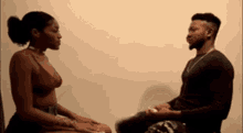 a man and a woman are sitting next to each other looking at each other