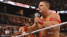 a man in a wrestling ring is talking into a microphone with a watermark that says usa