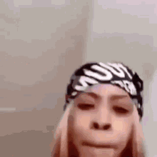 a close up of a woman wearing a headband and making a funny face .