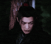 a close up of a man 's face with long hair in the dark