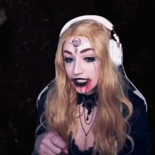a woman wearing headphones and a wig with blood on her face .