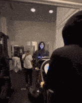 a woman taking a picture of herself in a gym while a man watches