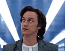 a man in a suit and white shirt is looking up at something