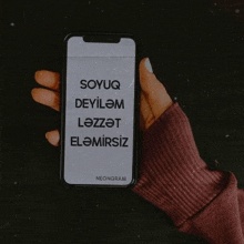 a person is holding a cell phone that says soyuq deyilem lezzet elemirsiz